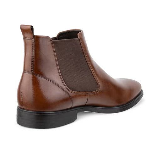A brown leather Chelsea boot with a black sole, shown from a three-quarters rear angle on a white background.