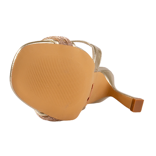 Tan sole of sandal with decorative straps on a white background