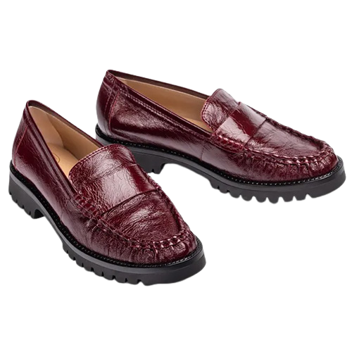 Burgundy patent leather loafers featuring a classic penny loafer design, and chunky black lug soles, shown from the side on a white background.