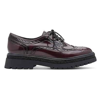 Burgundy brogues with black sole on a white background