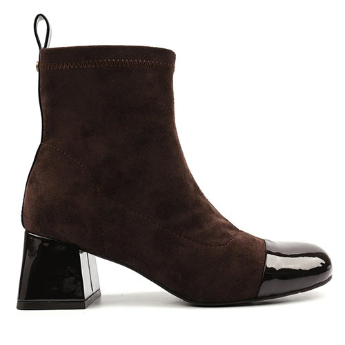 Brown ankle boot with black patent leather cap and block heel on a white background