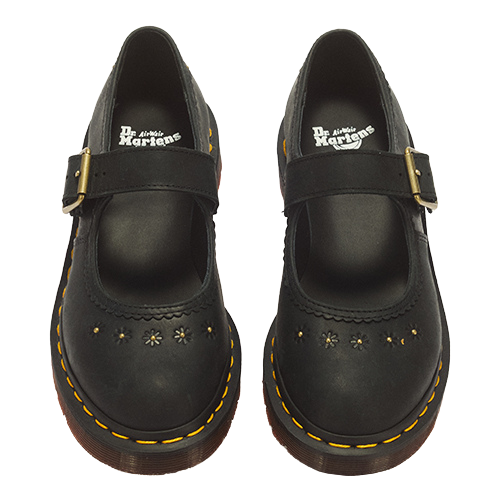 A pair of black Dr. Martens Mary Jane boots with gold-tone buckle straps, floral perforations, and signature yellow stitching on a white background.