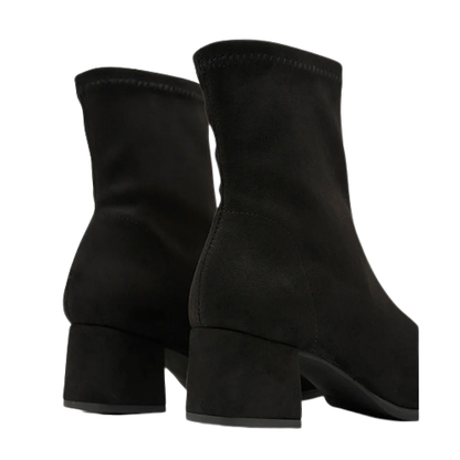 Black suede ankle boots on a white background