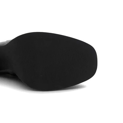 Close-up of the black rubber sole of a boot on a plain white background.