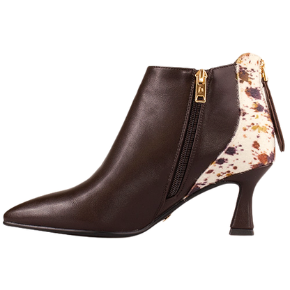 A dark brown leather ankle boot with a pointed toe, a mid-height stiletto heel, and a side zipper. The back of the boot features a cream-colored patch with a brown and black speckled pattern, finished with a gold-tone zipper pull.