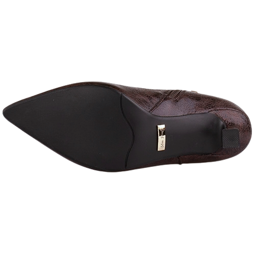 A close-up of the outsole of a pointed-toe dress shoe, showing a black rubber sole and a dark brown textured leather upper with a small gold metal logo plaque.