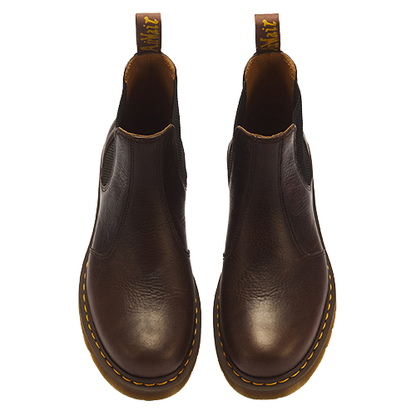 A pair of dark brown leather Chelsea boots shown from a top-down view on a solid white background. The boots feature elastic side gore panels, yellow welt stitching around the sole, and a tan pull tab with yellow branding.