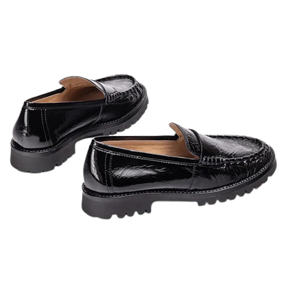 A pair of black patent leather loafers with a crocodile-embossed texture and chunky lug soles, shown on a plain white background.