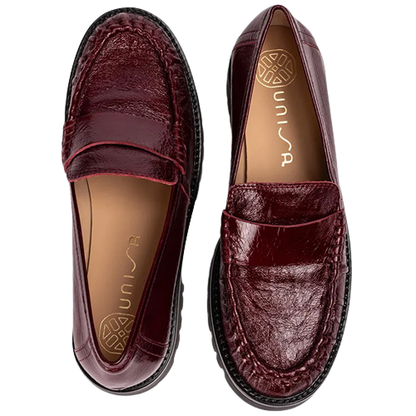 Burgundy patent leather penny loafers with detailed stitched uppers, tan lining and chunky black lug soles, shown from a top-down view on a white background.