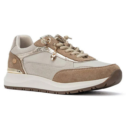 A low-top trainer in beige and brown suede with metallic gold accents, beige laces, and a chunky off-white midsole, shown from a side profile on a white background.
