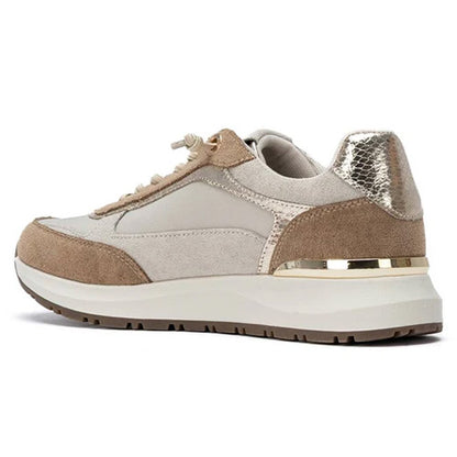 A low-top trainer in beige and taupe suede with a metallic silver snakeskin heel accent and a gold metallic band around the midsole, shown from a side profile on a white background.