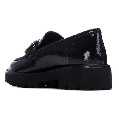 A single black patent leather loafer with a chunky lug sole, shown from a side profile view against a plain white background.