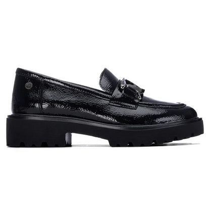 A single black patent leather loafer with a chunky lug sole and a decorative metal buckle detail on the vamp, shown in a side profile against a white background.