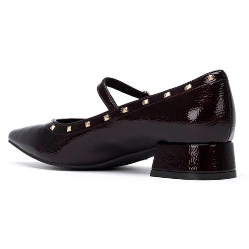 A burgundy patent leather Mary Jane shoe with gold pyramid studs, shown from a side profile view on a white background.