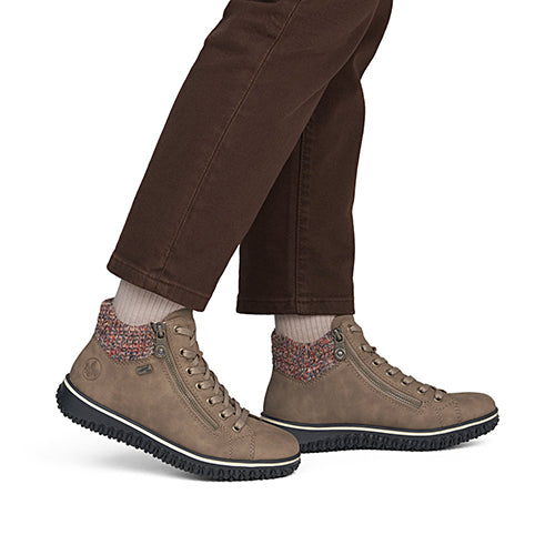 Brown shoes worn with brown pants on a white background