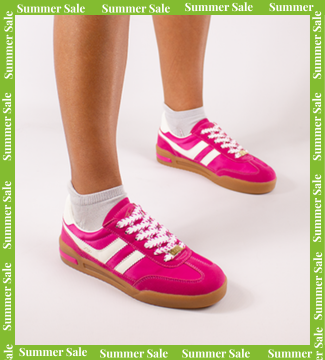 Pink trainers with white laces worn by a person on a light gray background, with &